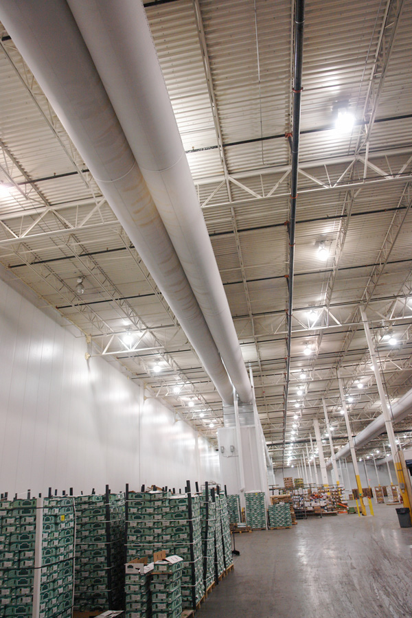Fabric air-distribution ducts running the length of a cooler bay above racked produce