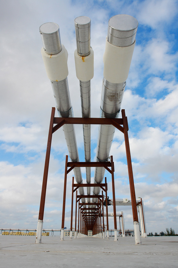 Insulated refrigerant mains carried along a pipe rack across the roof