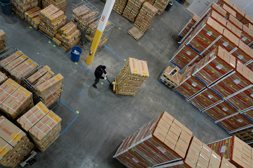 The working floor seen from the building's upper level, pallets and crews below