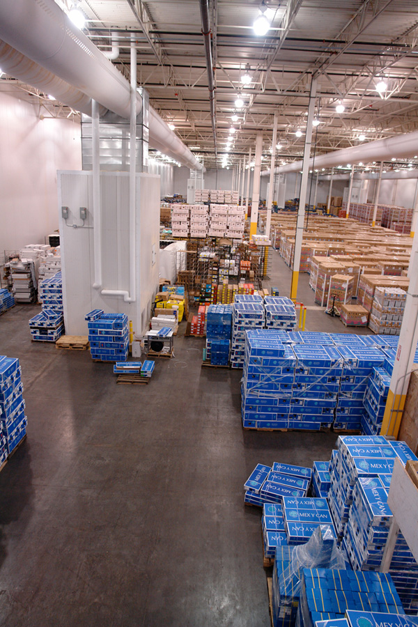 Long racked aisles seen from above, with blue export cases stacked on the cooler floor