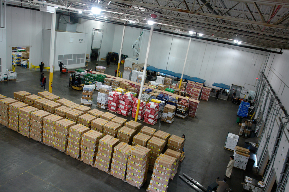 The Flora Logistics warehouse floor seen from above, stacked with palletized cartons of perishables